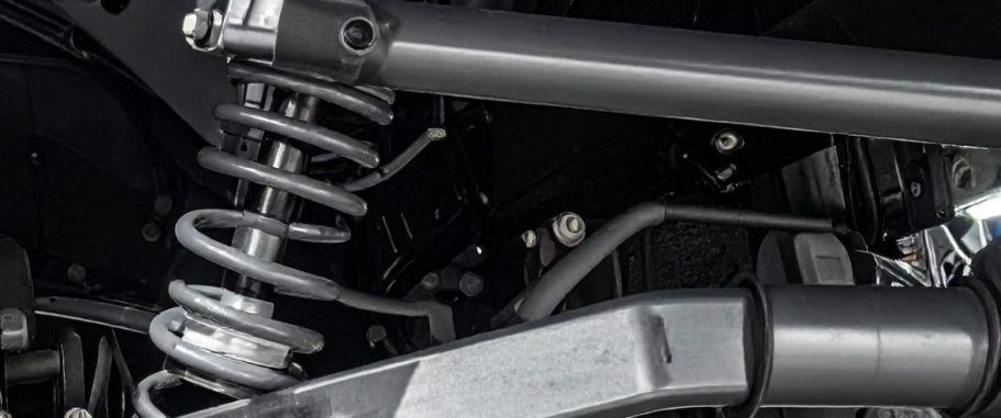 Close-up of a vehicle's suspension system with a coil spring and shock absorber.