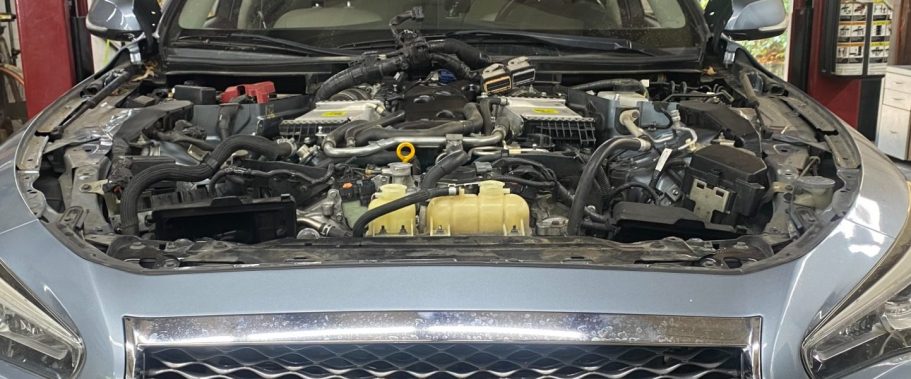 Automobile with hood open to view engine.